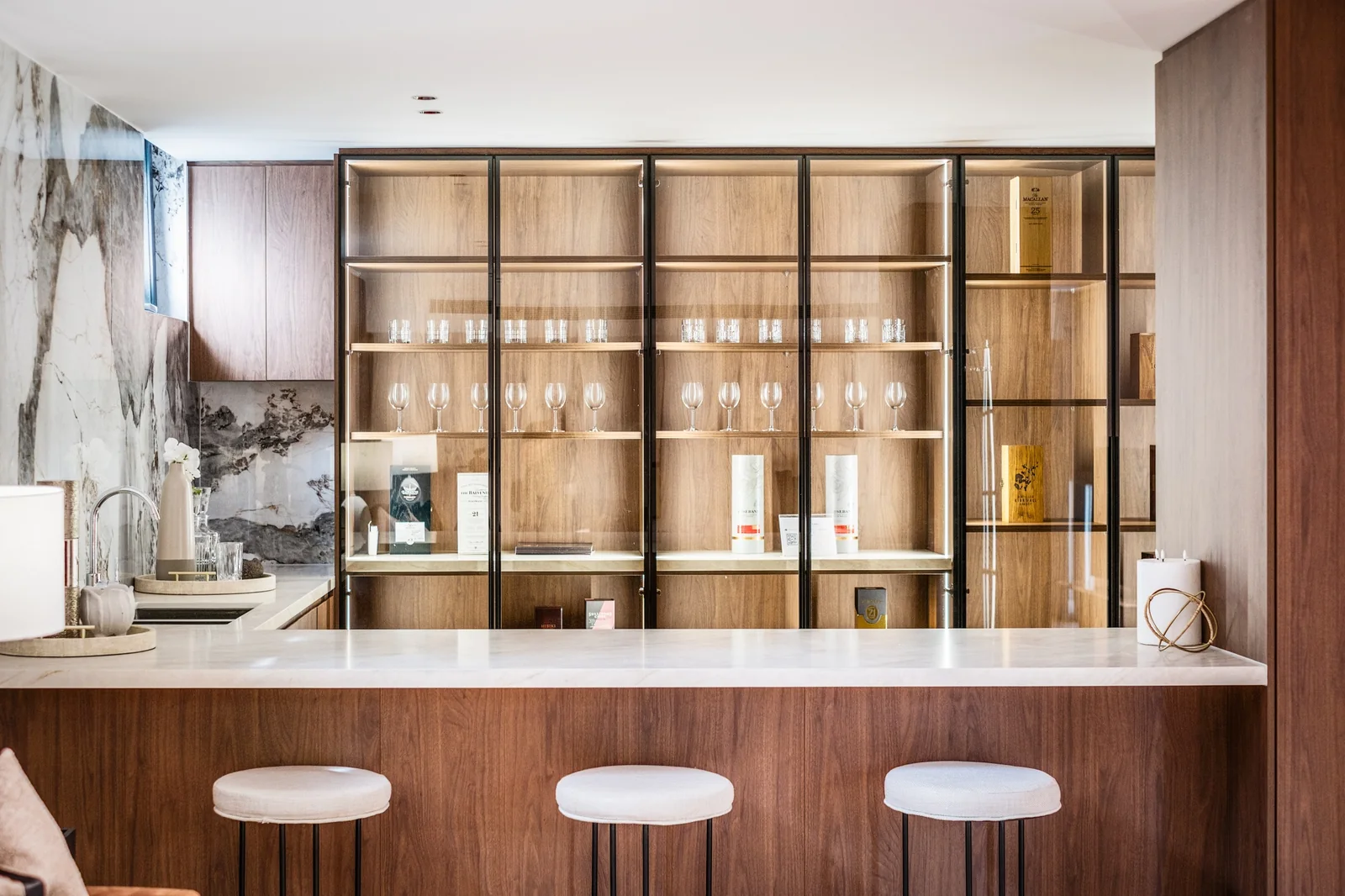 Timber bar cabinetry with glass display doors and integrated lighting