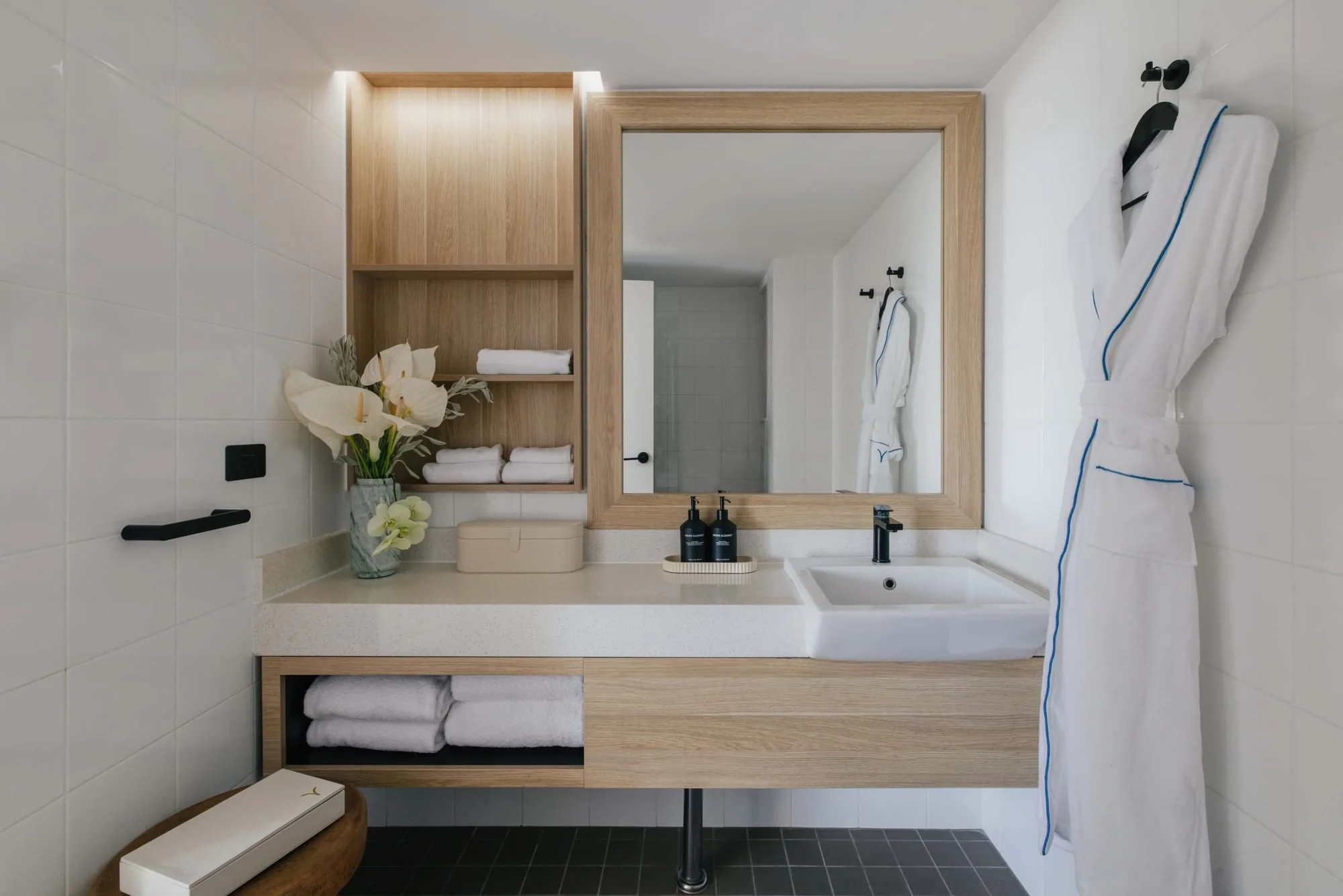 Timber bathroom vanity with open towel storage and matching mirror